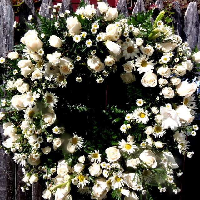 White rose and daisy wreath on a dark background