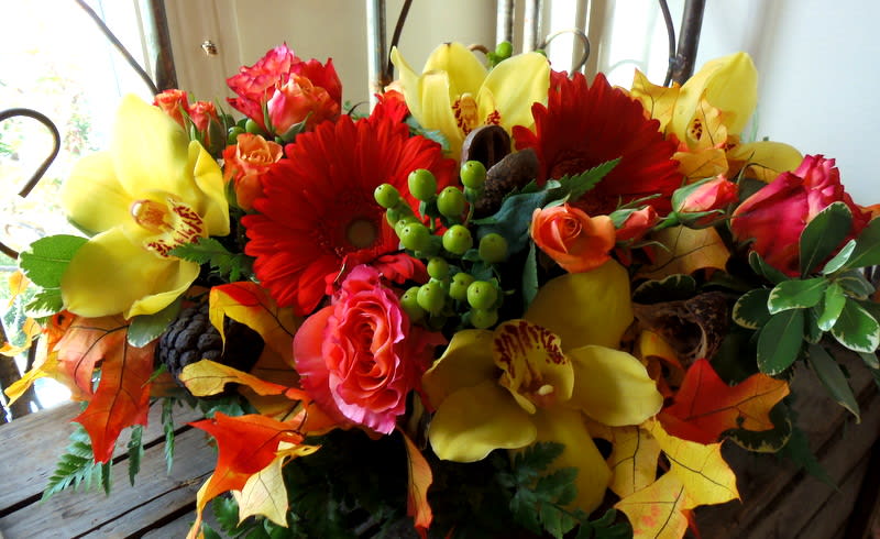 Bouquet of red gerbera daisies, pink roses, and yellow orchids