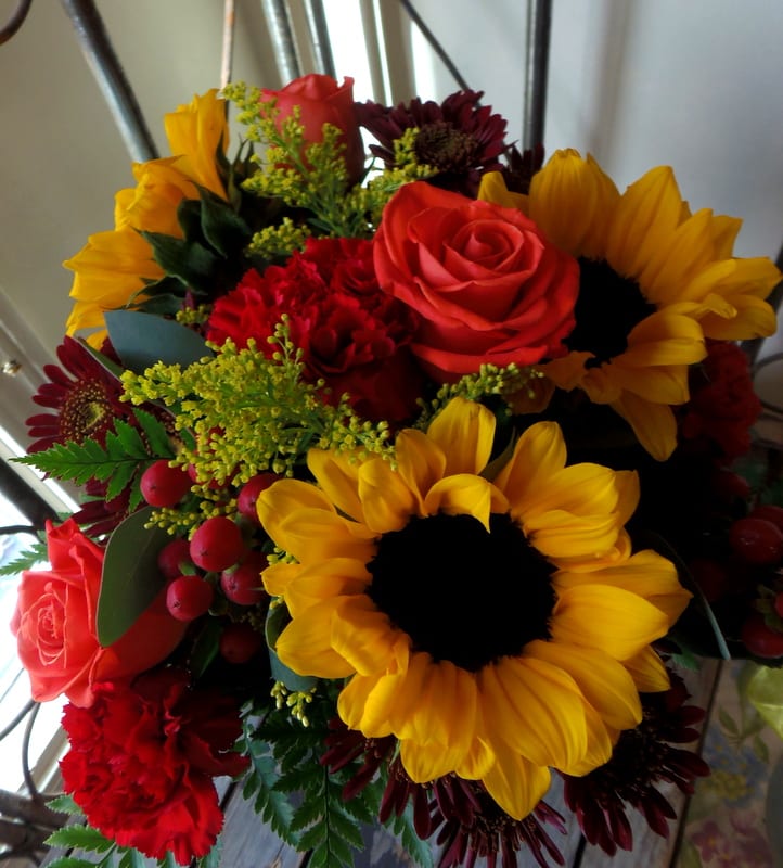 Bouquet of sunflowers, red roses, and burgundy daisies