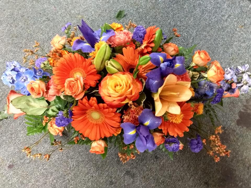 Colorful mixed bouquet with orange gerberas, roses, and purple irises