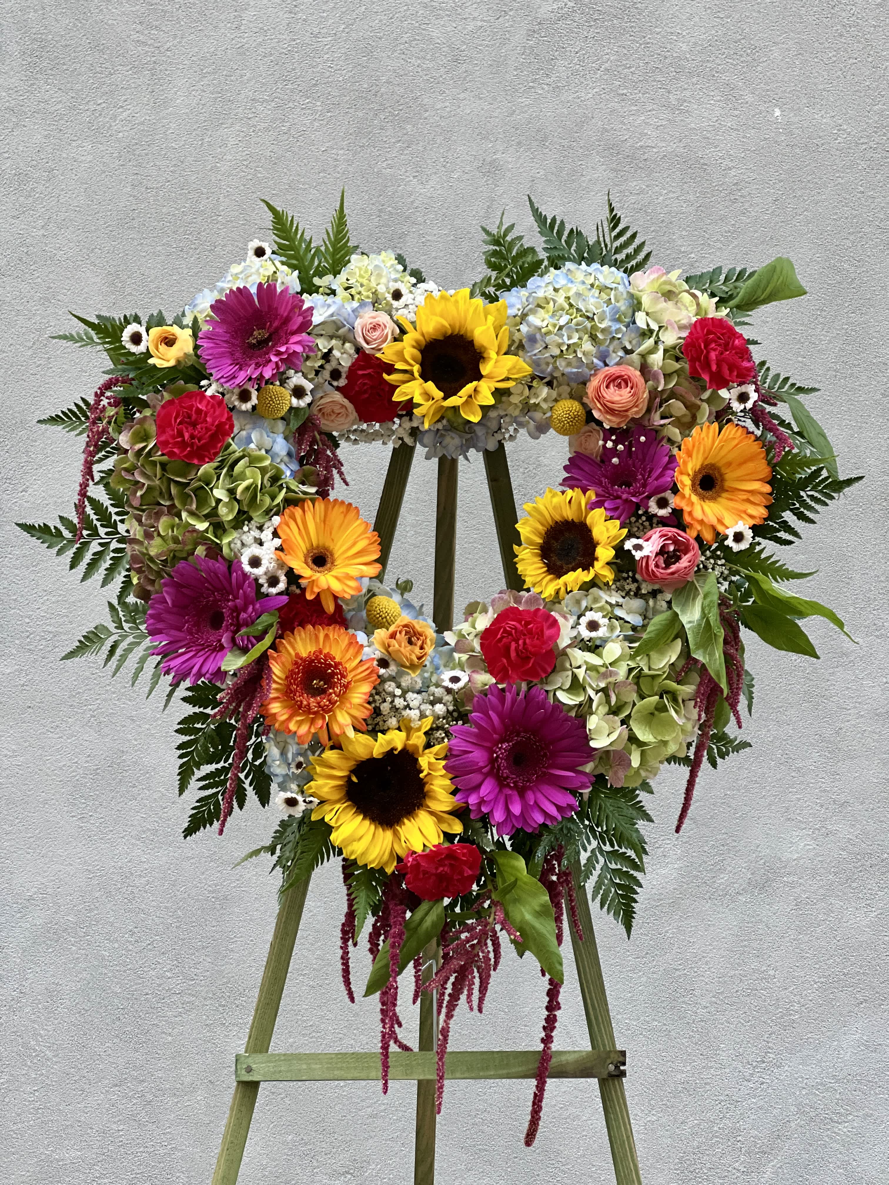 Vibrant Heart - Standing Heart spray filled with colorful flowers.
