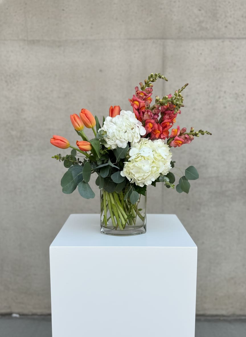 Peaches + Herb - Reunited and it it feels so good! Inspired by the dynamic 70's duo Peaches and Herb, this lovely will have its recipient shaking it's groove thing in celebration This lovey lush bouquet is full of fun, class and romance.  Carefully crafted with tulips, snapdragons, hydrangeas, eucalyptus in a unique shaped vase and accented with minty velvet ribbon. 