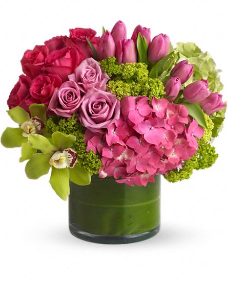 Pink roses, tulips, and hydrangea in a green glass vase