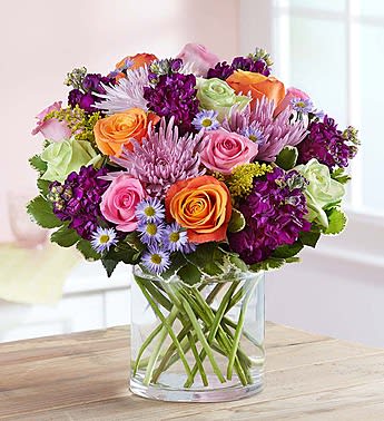 Beauty in Abundance - Express your love in a big way! Overflowing with coral, pink and green roses, and accented by rich purple blooms, this gorgeous, hand-designed bouquet is a gift that will fill their heart with joy, whether you send it for a birthday, anniversary or as an out-of-the-blue, romantic surprise.