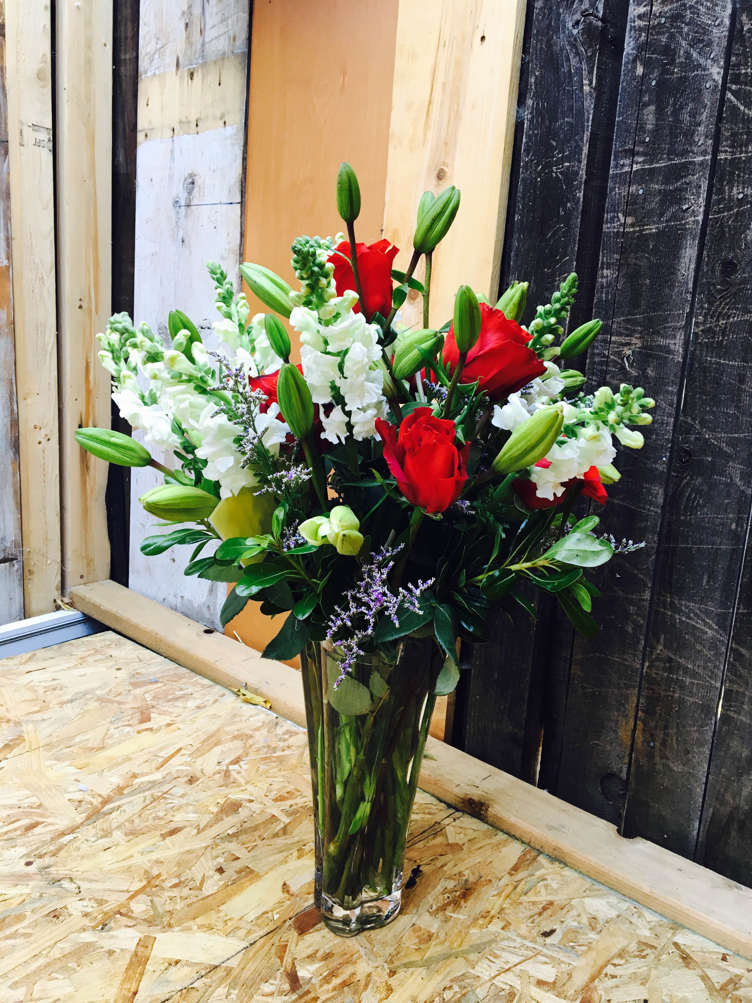 Red roses and white snapdragons in a clear glass vase