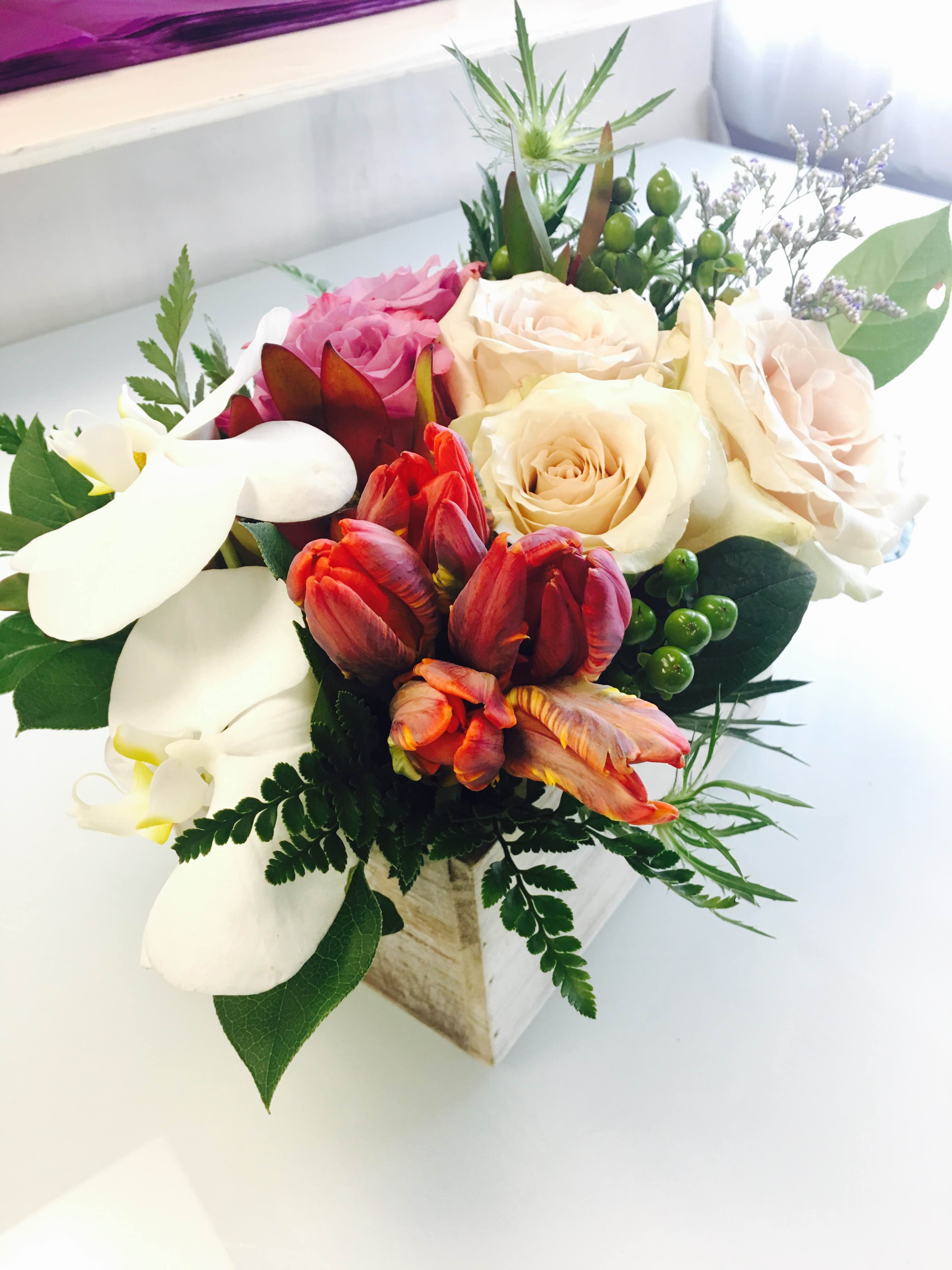Mixed bouquet with roses, tulips, and white calla lilies in a wooden box