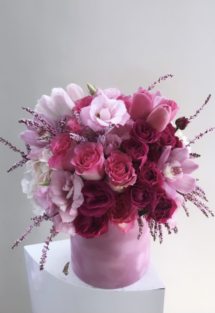 Pink and white bouquet of roses and tulips in a pink box