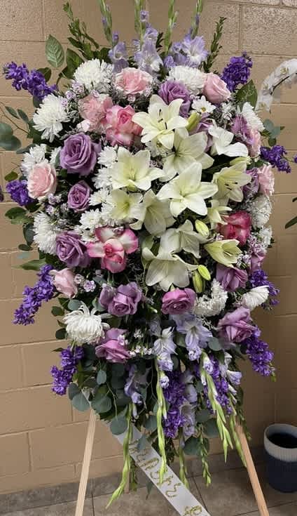 Large standing floral spray with pink, purple, and white blooms