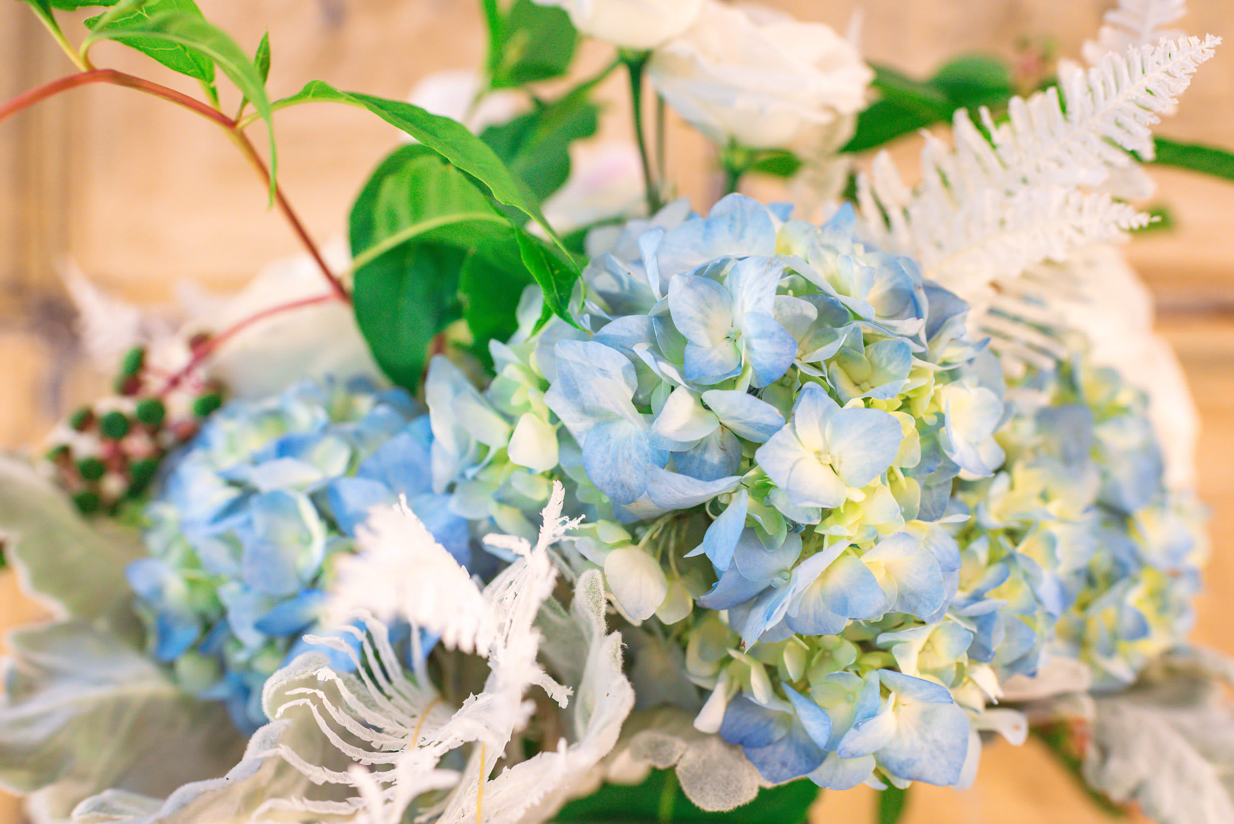 Blue hydrangea bouquet with white accents and green foliage