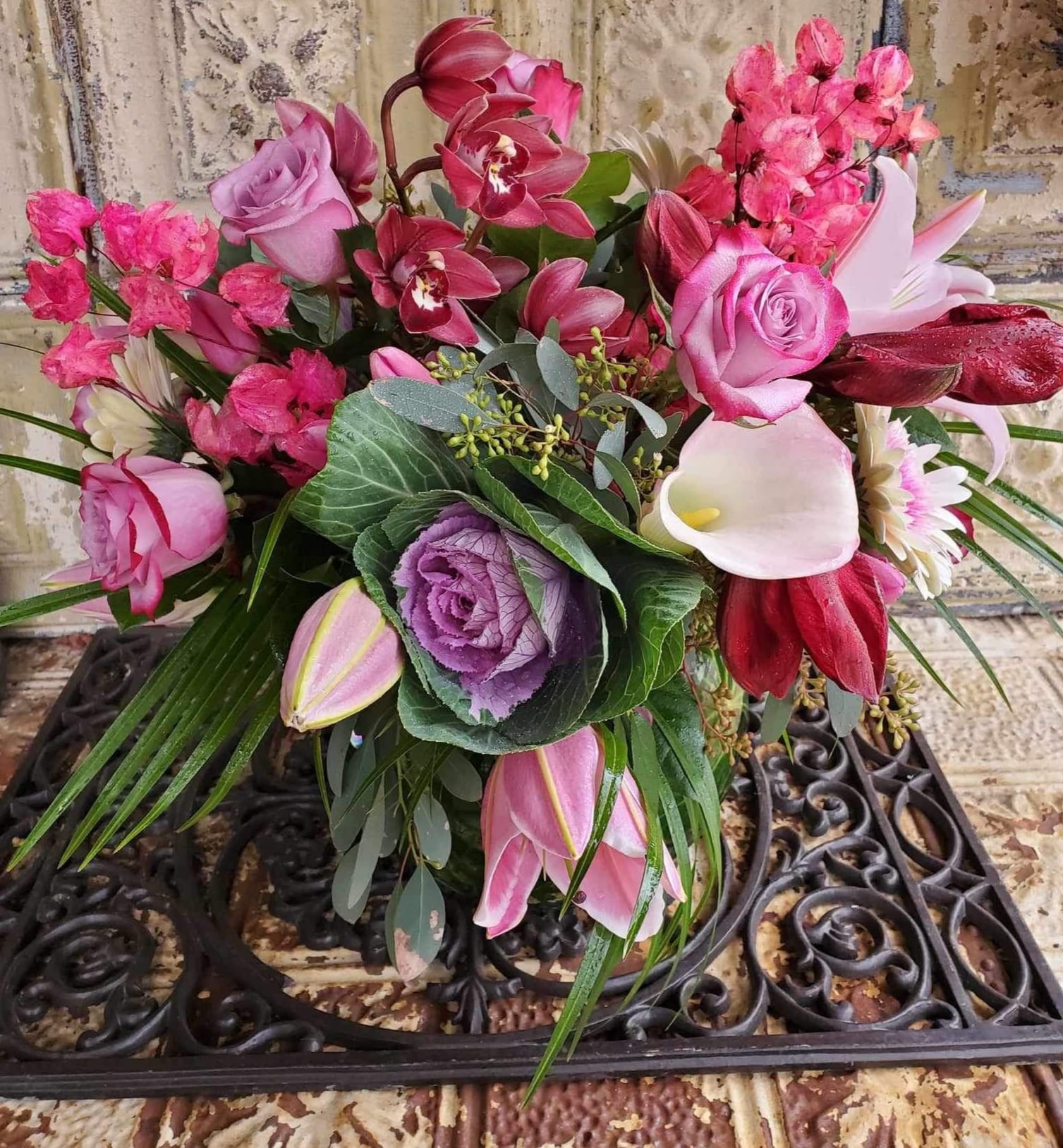 Mixed bouquet with pink roses, orchids, calla lilies, and purple cabbage