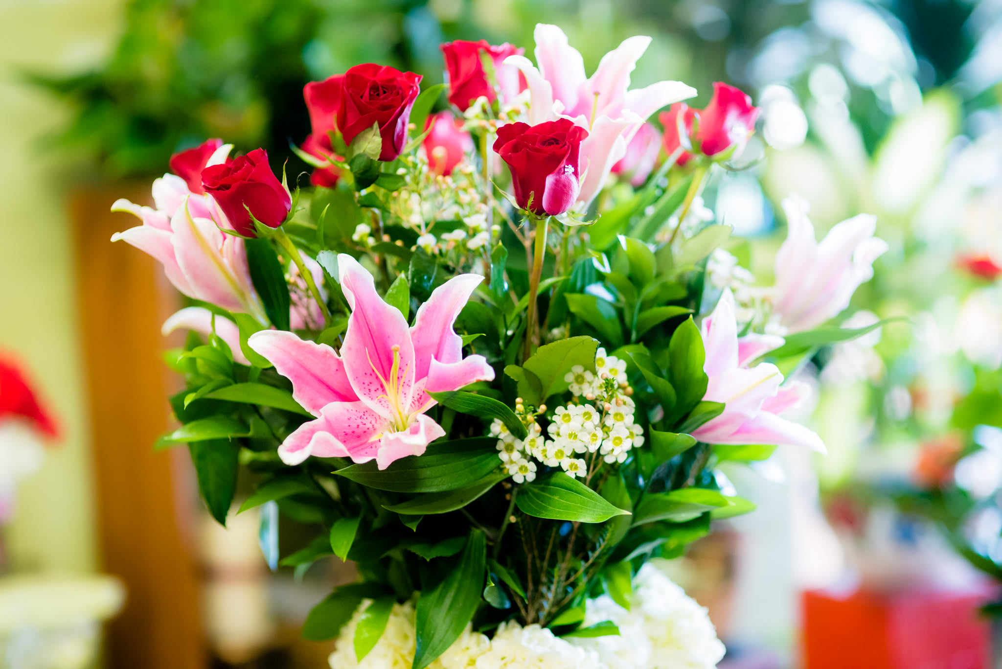 Bouquet of pink lilies and red roses with greenery
