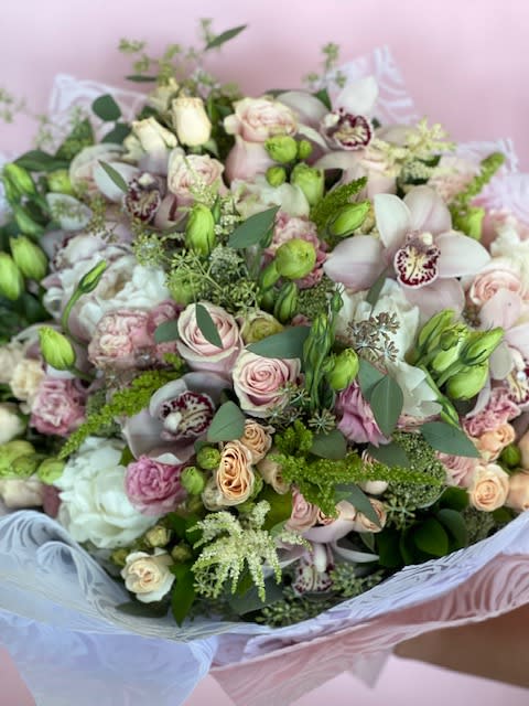 Large bouquet of pale pink and white flowers with green accents