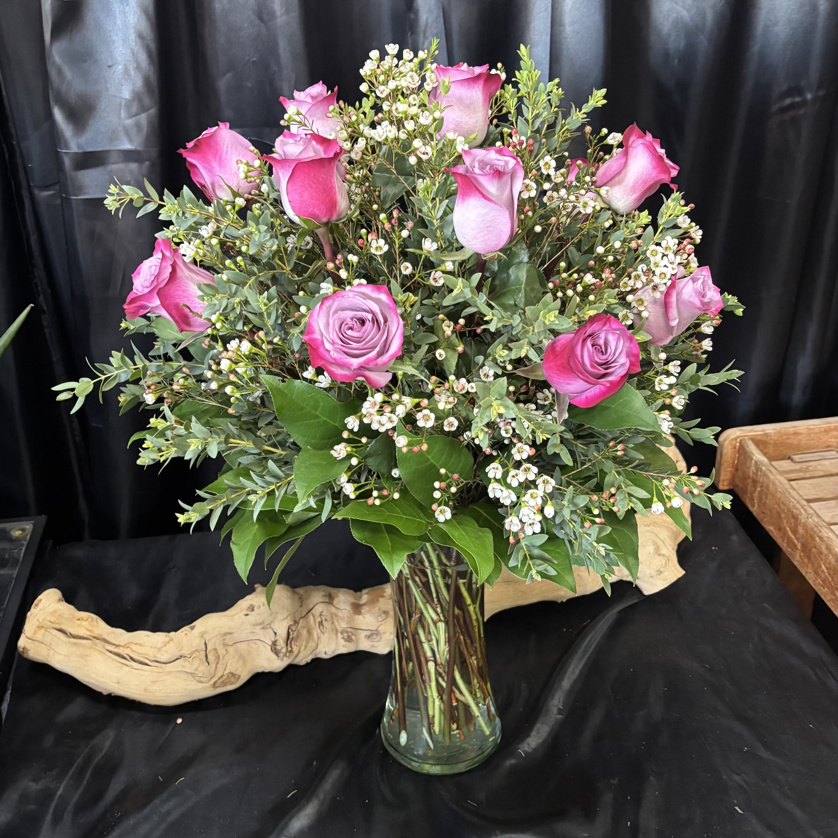 Pink roses arranged in a clear glass vase with small white filler flowers