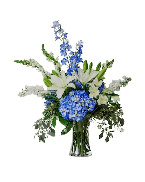 Blue and white floral arrangement in a clear glass vase