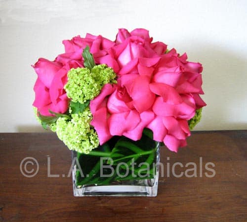 Pink rose bouquet with green hydrangea in a clear square vase
