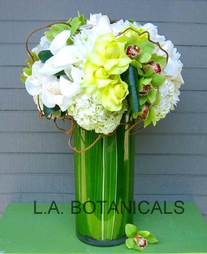 Tall bouquet of white and lime-green flowers in a green vase