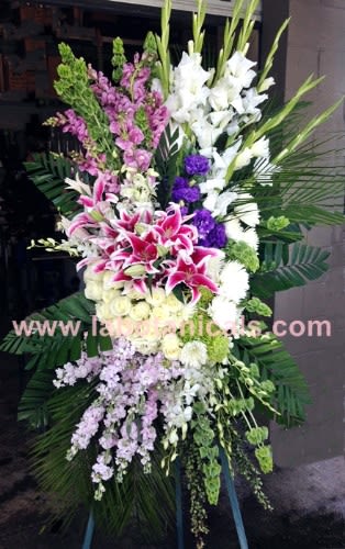 Tall standing floral spray with pink and white lilies and purple accents