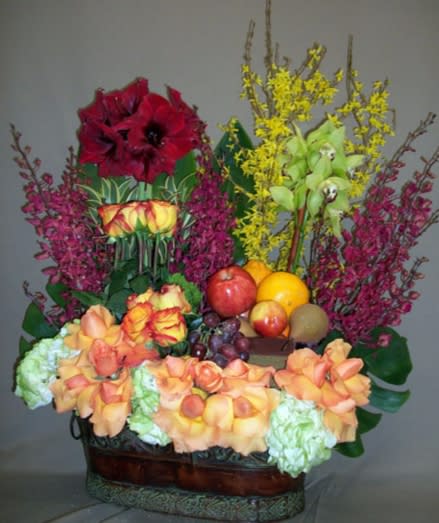 Colorful floral arrangement in a basket with fruit accents