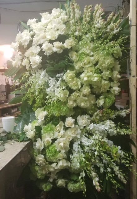 Large white and green floral arrangement with cascading blooms