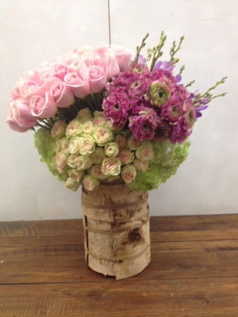 Pink and purple floral arrangement in a birch bark vase