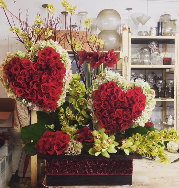 Heart-shaped red rose arrangements with orchids in a decorative box