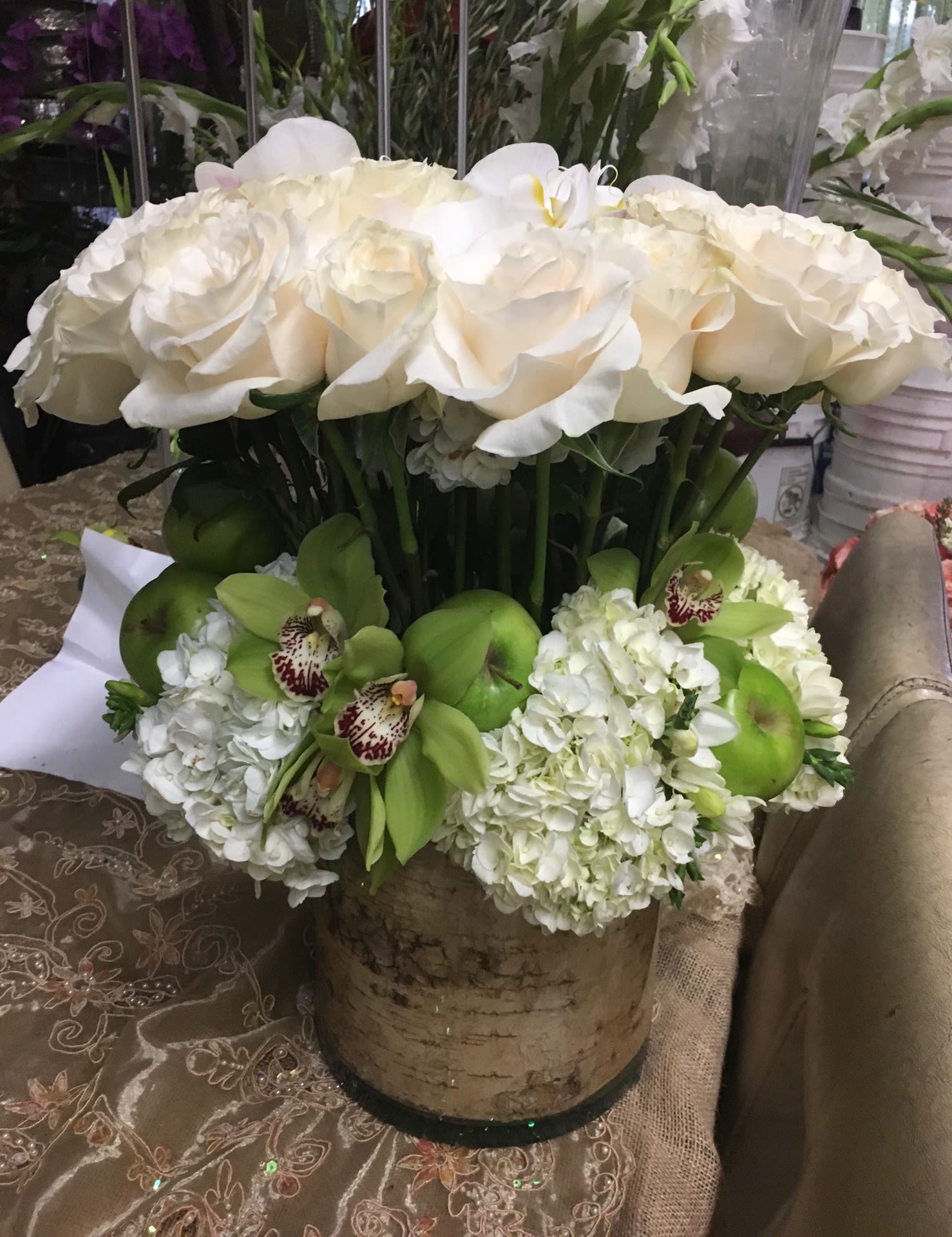 White rose and orchid arrangement in a birch-style container