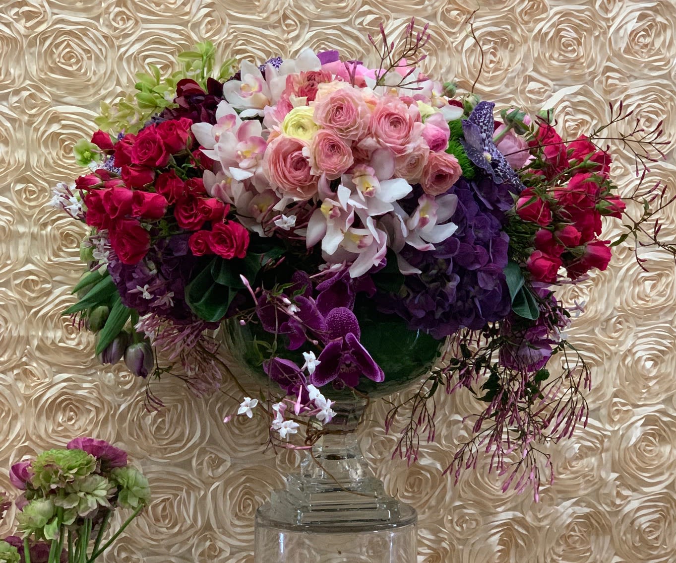 Large bouquet of pink, purple, and white flowers in a clear vase