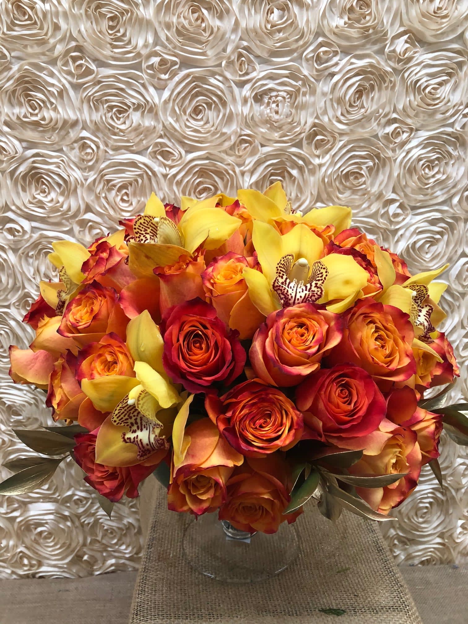 Bouquet of orange and red roses with yellow orchids