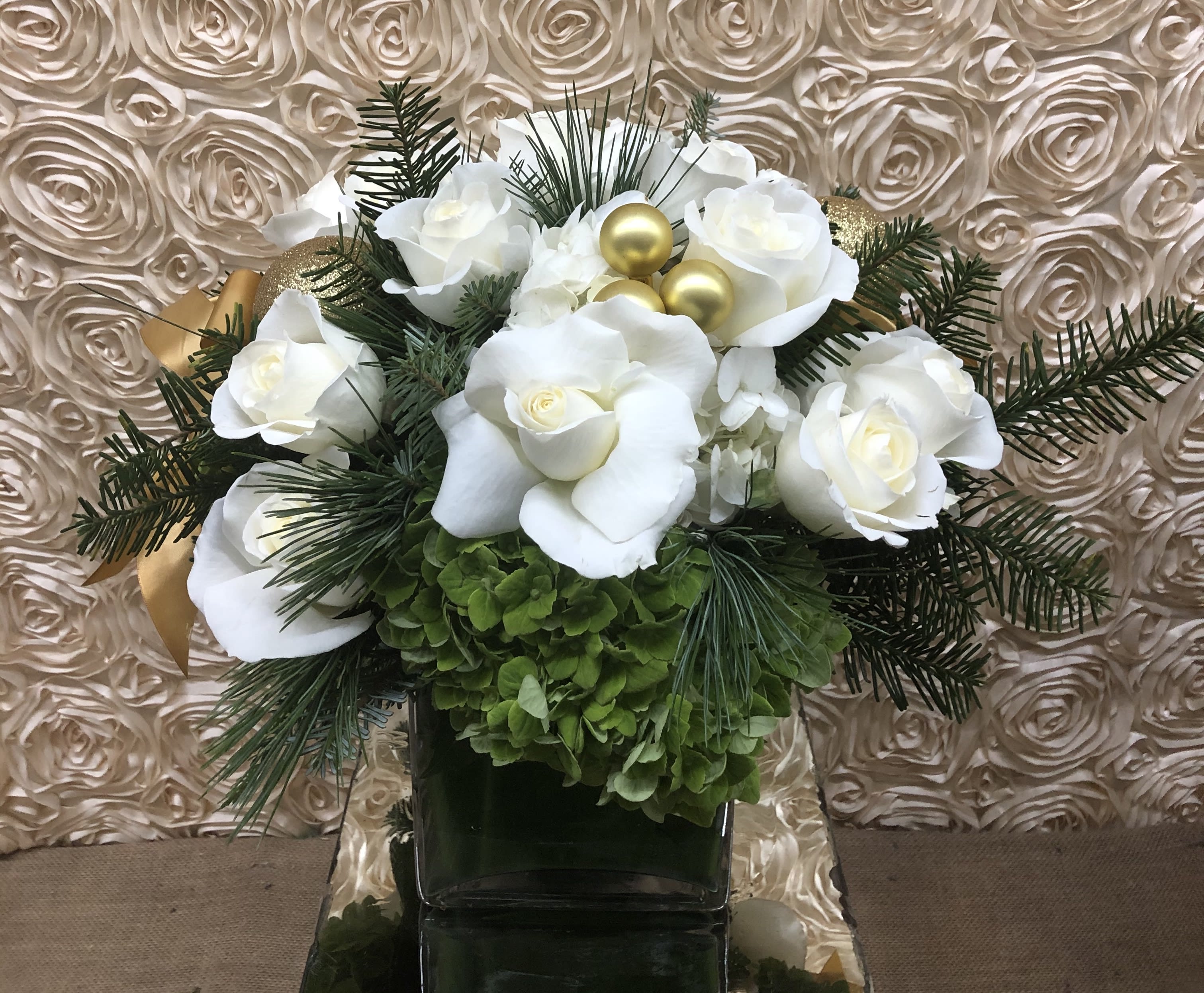 White roses and green hydrangeas in a dark vase with gold ornaments