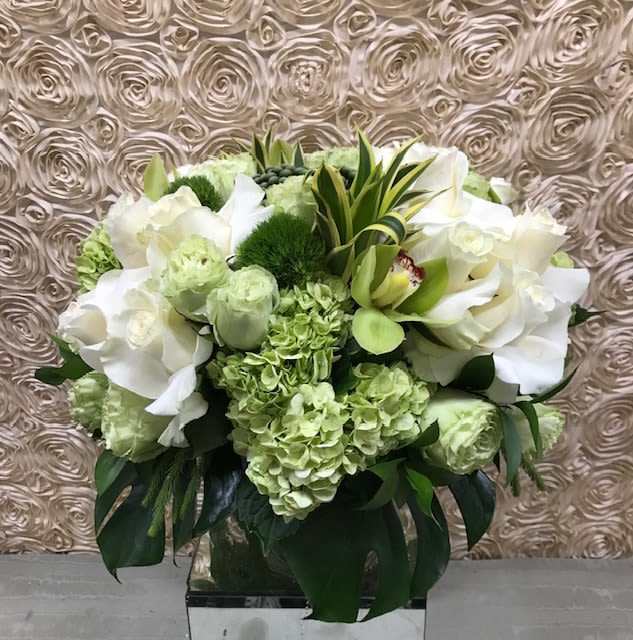 White and pale green floral arrangement in a clear vase
