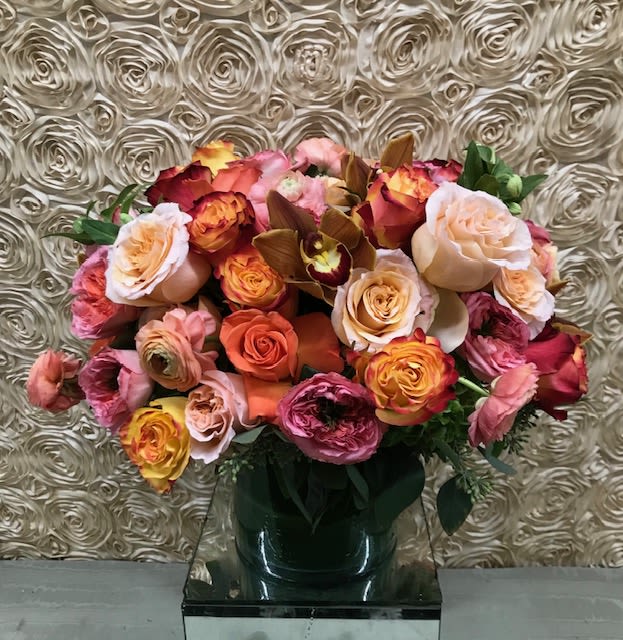 Mixed roses in a dark vase against a textured wall