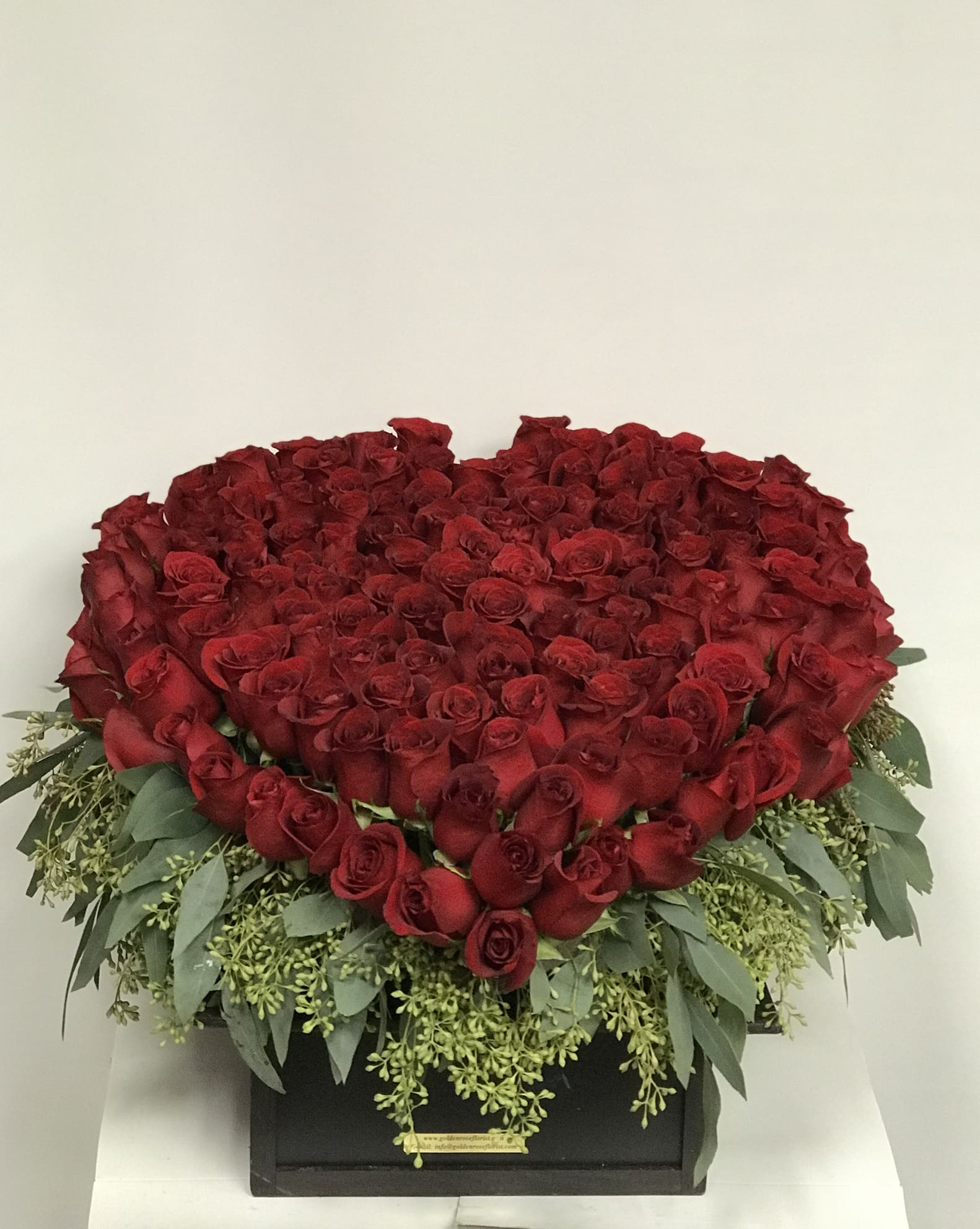 Grandeur  Heart - PREMIUM RED ROSES APROX 200 STEMS  A magnificent heart-shaped arrangement featuring 200 premium red roses, accented with lush greenery for a perfect touch of elegance. Presented in a sleek black box with a gold plaque, this design exudes sophistication and romance. Ideal for grand gestures, anniversaries, Valentine’s Day, or any moment that deserves a statement of love and luxury.   Substitution &amp; Design Policy  AS SIMILAR AS POSSIBLE  Each floral arrangement is custom-designed and handcrafted using the freshest flowers, containers, decorative accents, and materials available at the time of creation. Due to seasonal availability, immediate inventory conditions, market limitations, or unforeseen circumstances, substitutions of flowers, containers, or decorative elements may be necessary.  When substitutions occur, they will always be made with items of equal or greater value, while preserving the overall style, color palette, proportions, and design integrity of the original arrangement. The final product will be delivered as similar as possible to the design shown.  By placing an order, you acknowledge that all floral designs are unique and that natural variations are part of the artistic and handcrafted process. Our commitment is to deliver the most beautiful and refined version of each arrangement, consistent with our quality standards.