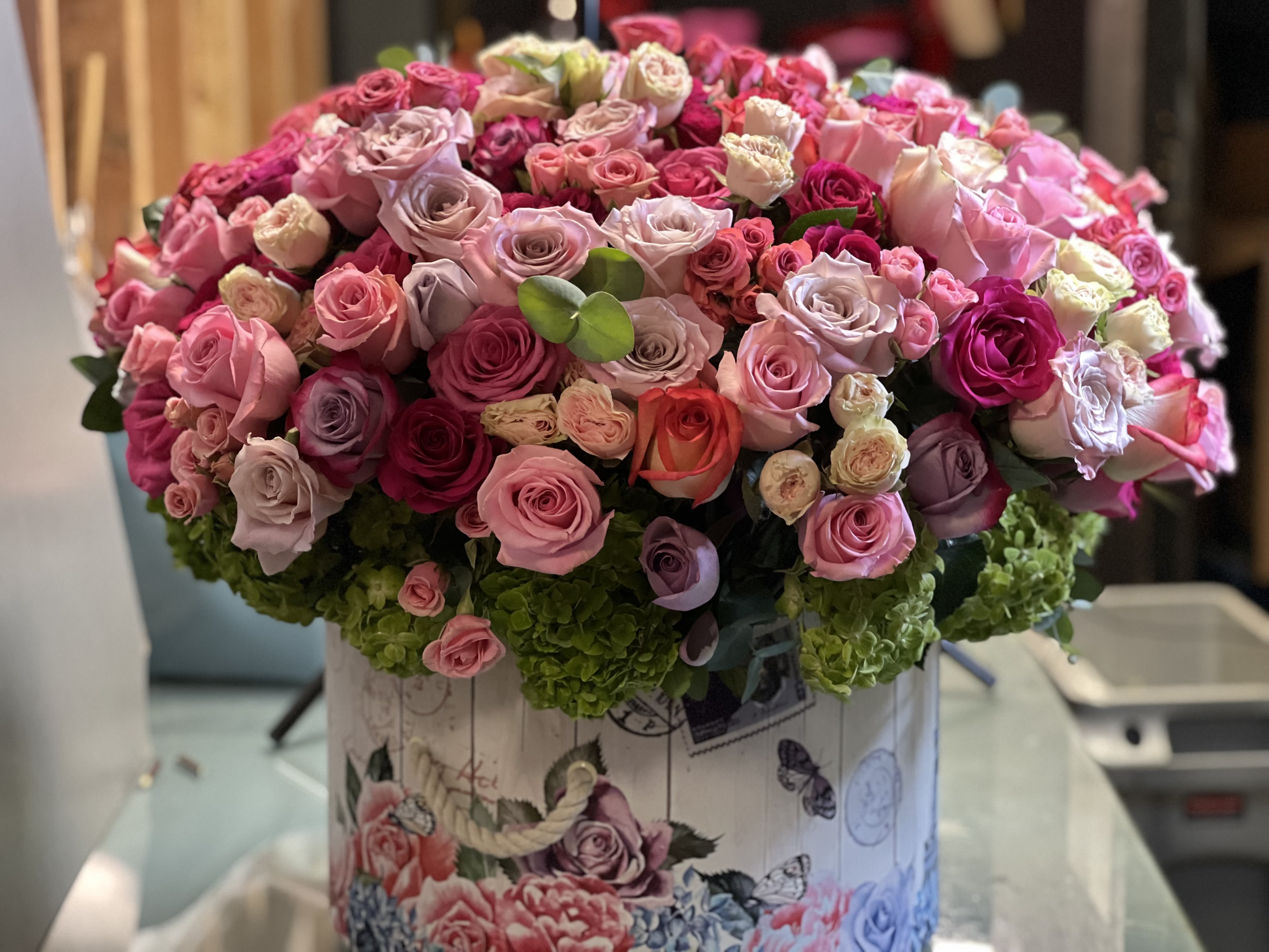 Large bouquet of pink and lavender roses in a decorative box