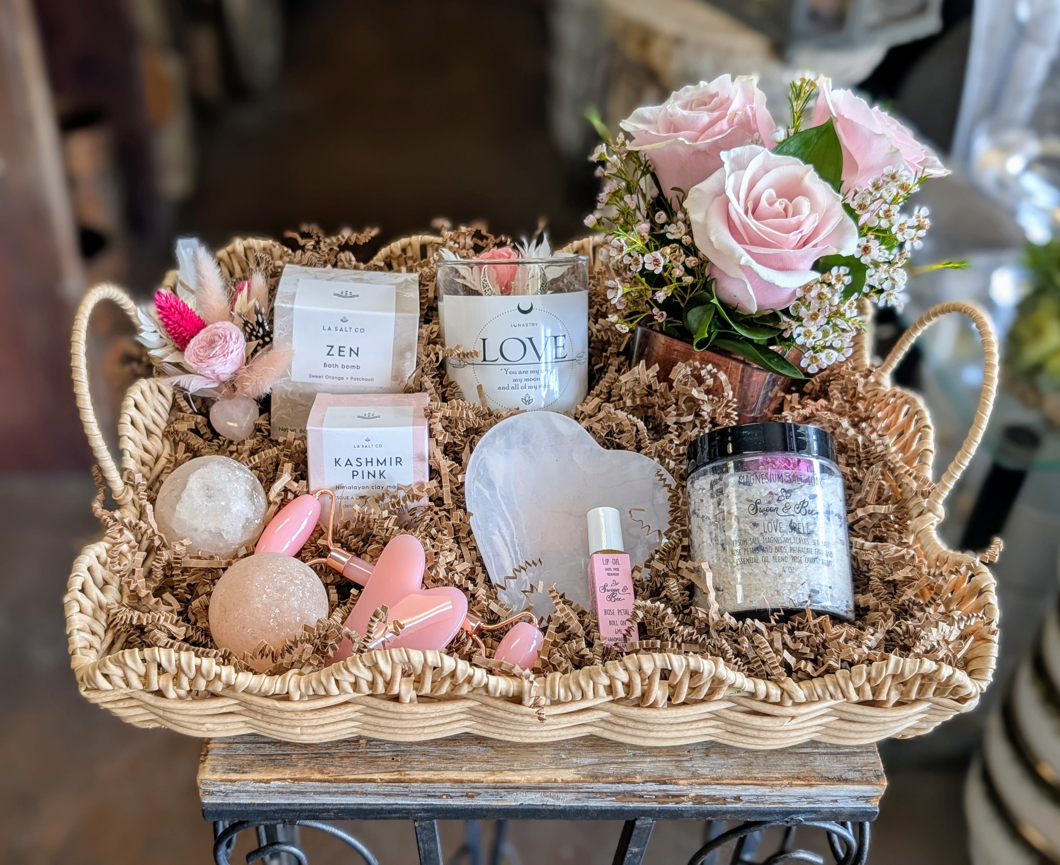Gift basket with pink roses and bath items in a woven tray