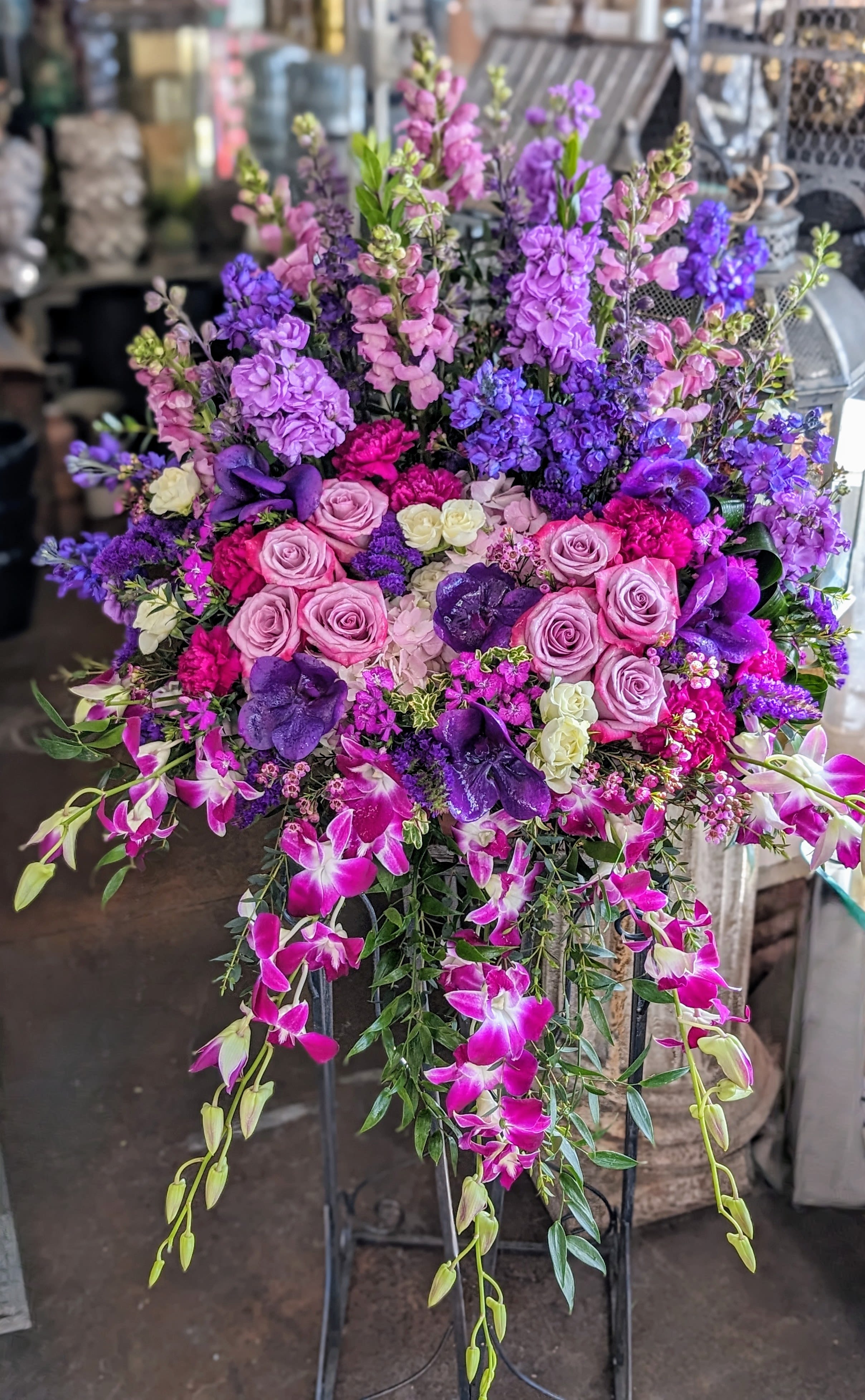 Large standing arrangement of pink, purple, and white flowers