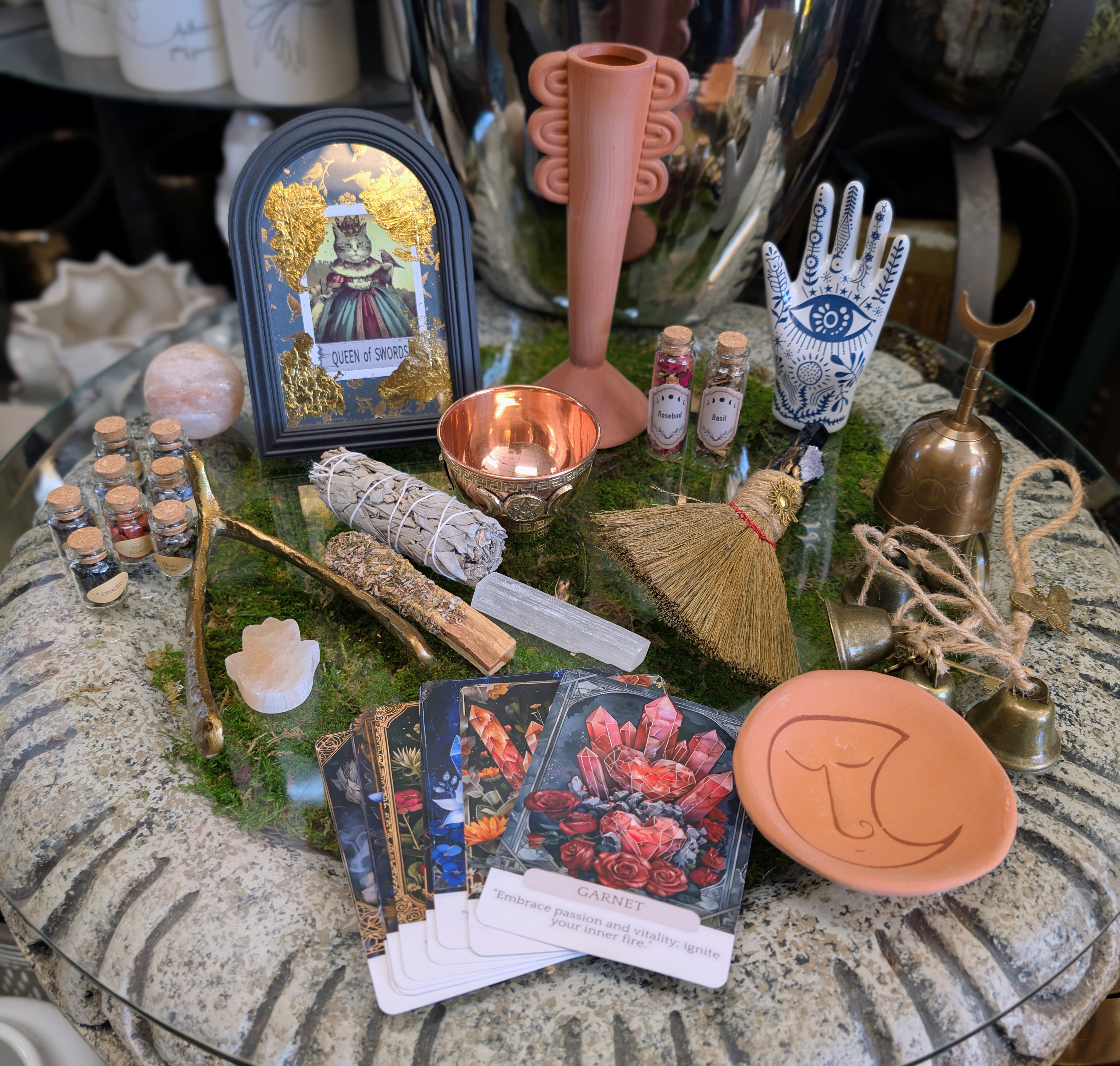 Assorted tarot and ritual items arranged on a glass table