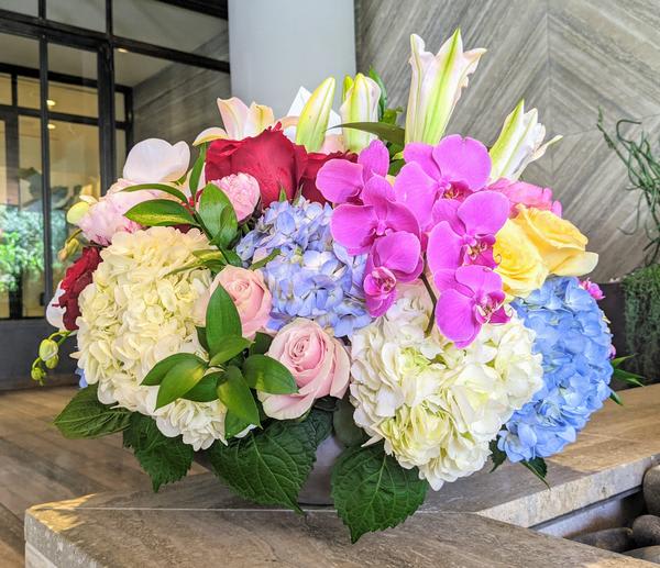 Large bouquet of hydrangeas, roses, lilies, and orchids in bright colors