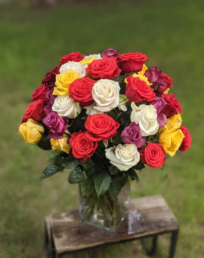 Bouquet of multicolored roses in a clear glass vase