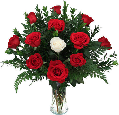 Red and white roses arranged in a clear glass vase