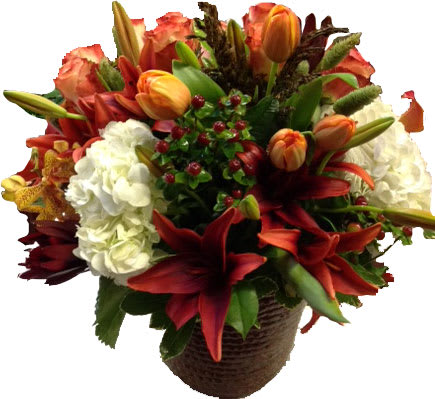 Mixed bouquet of red lilies, orange tulips, and white hydrangeas in a basket