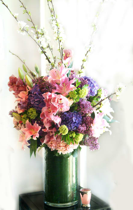 Tall bouquet of pink lilies and purple hydrangeas in a glass vase