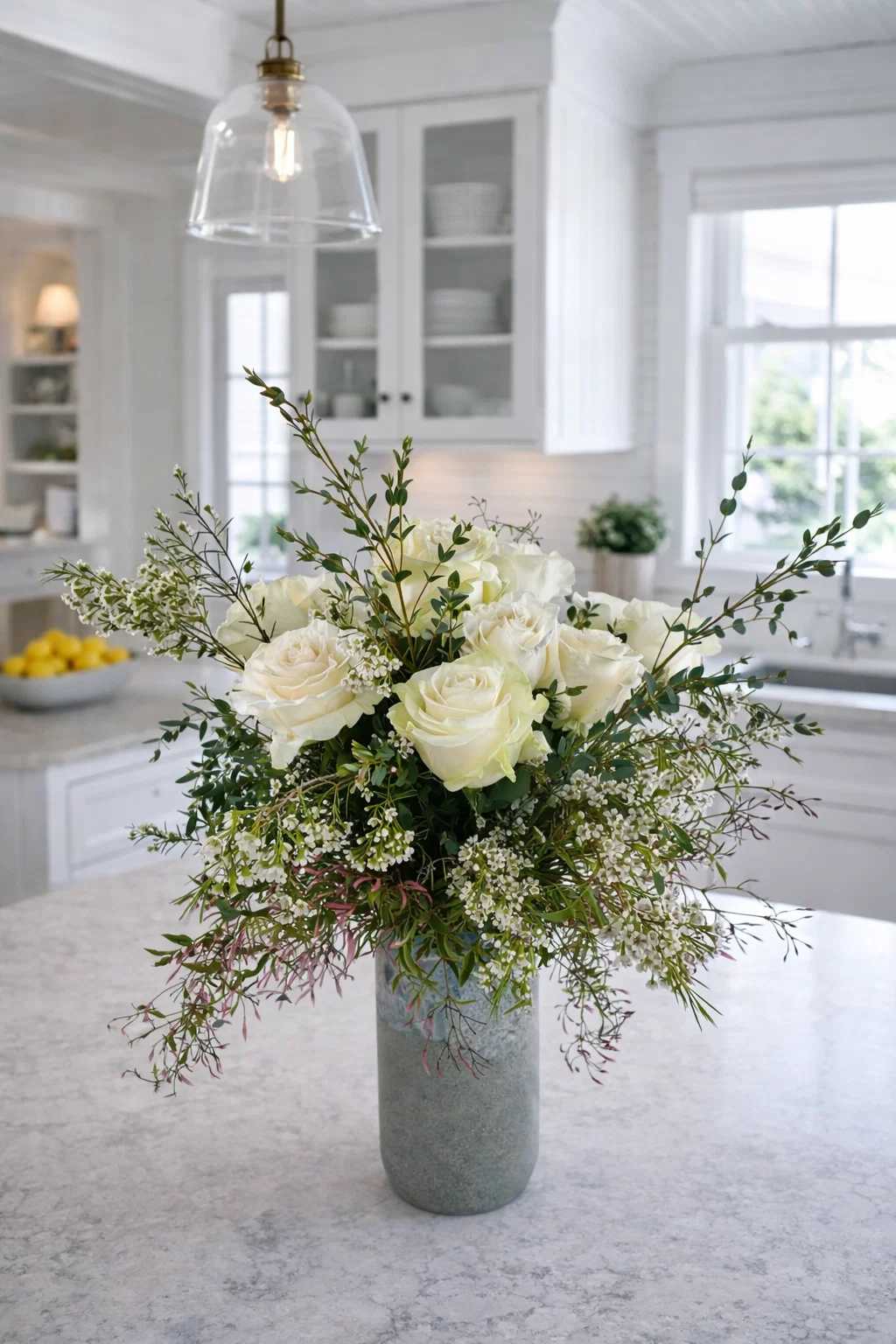 White rose arrangement in a tall gray vase