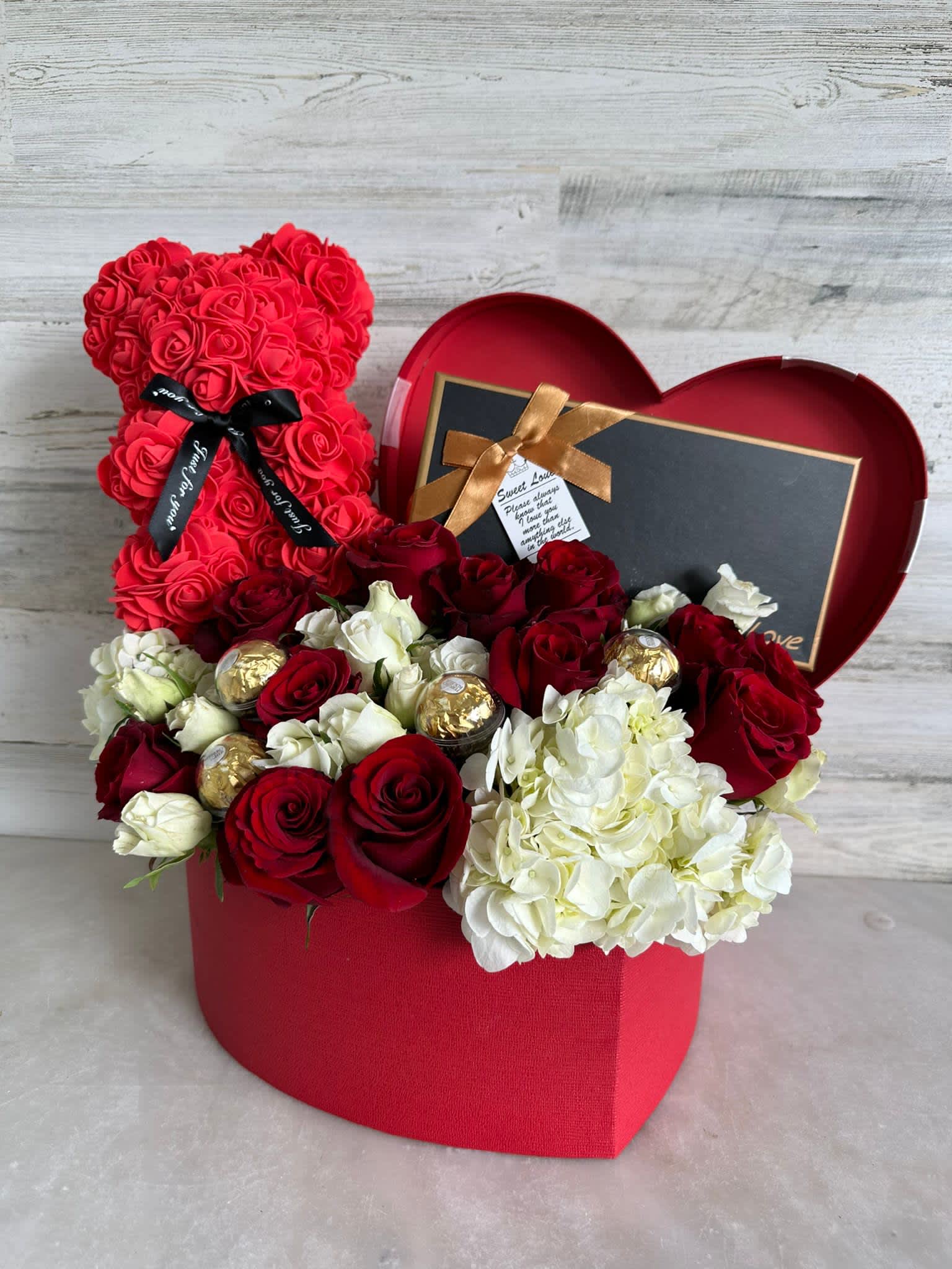 Red rose teddy bear and mixed roses in a heart-shaped gift box