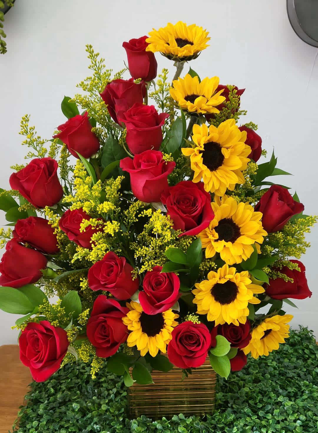Bouquet of red roses and yellow sunflowers in a woven basket