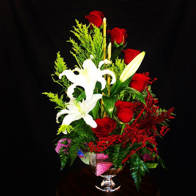 Red roses and white lilies in a clear glass vase