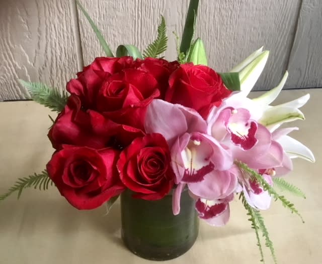 Red roses and pink orchids in a green vase