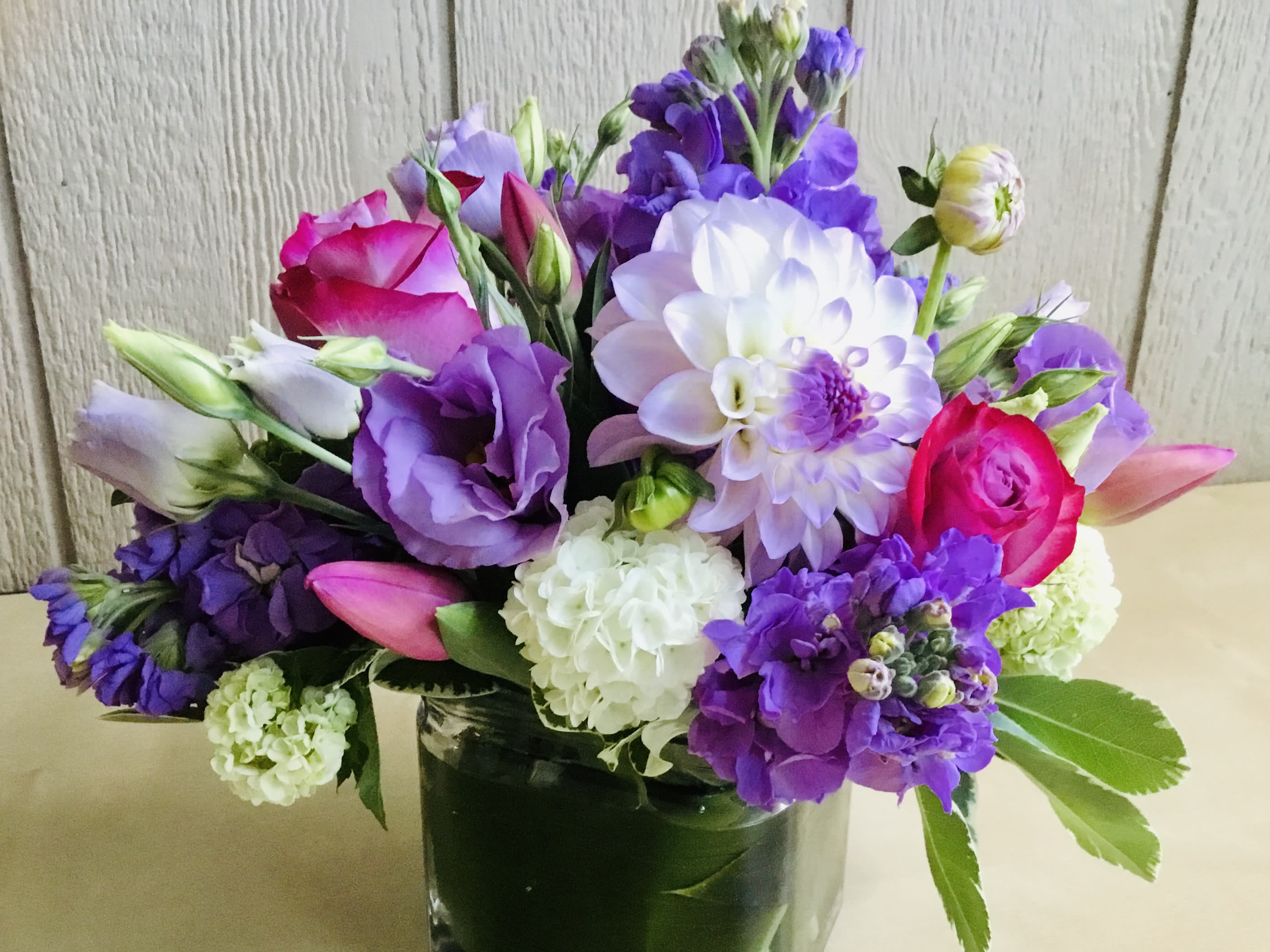 Purple, pink, and white mixed bouquet in a glass vase