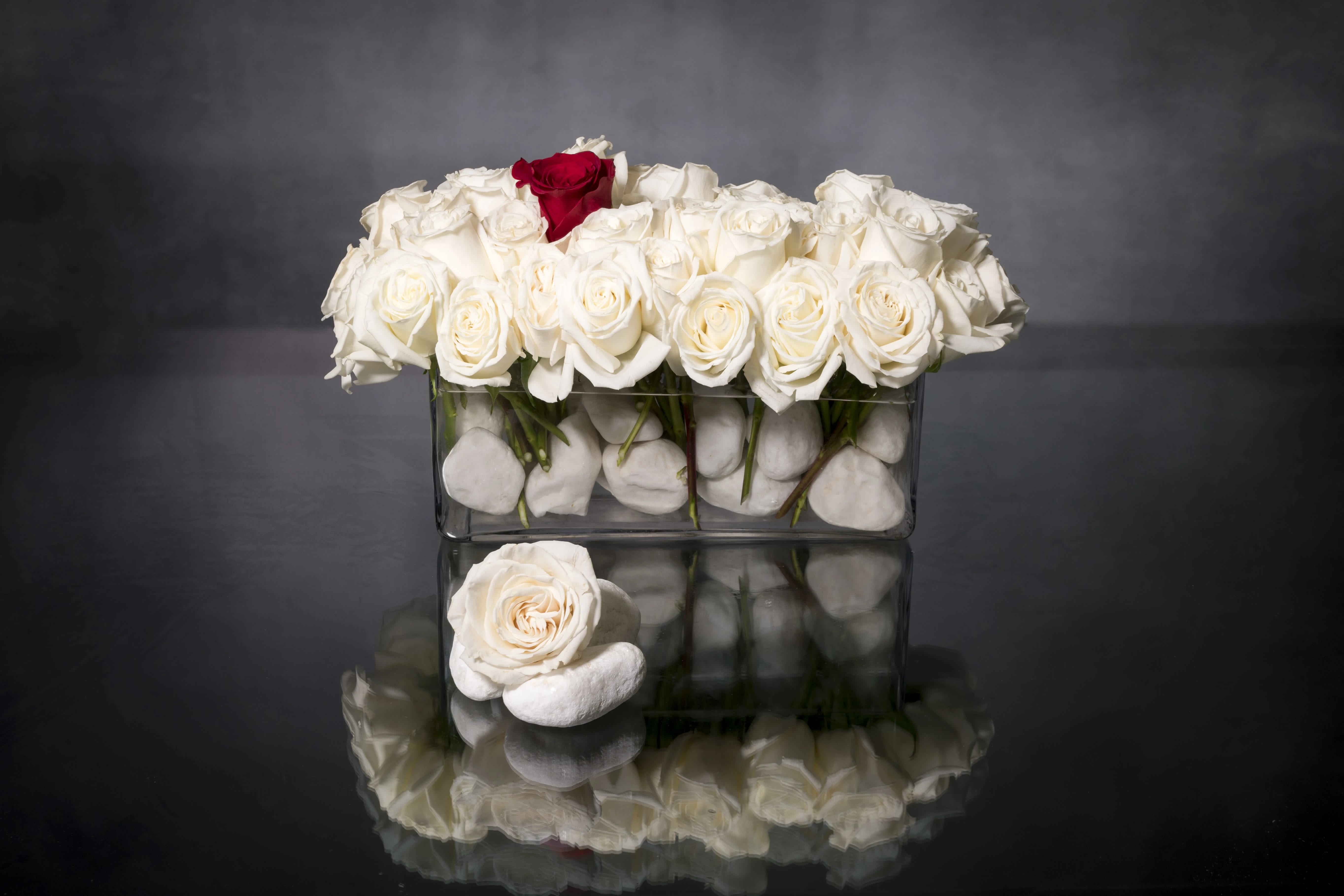 One of a kind - Valentine Edition - This sophisticated design features Creamy White Roses with one Deep Red Rose set in a stone glass vase.  Standard: 18 Roses  Deluxe: 36 Roses  Premium: 48 Roses  Deluxe as Shown in first picture  Deluxe and Premium shown in second pic