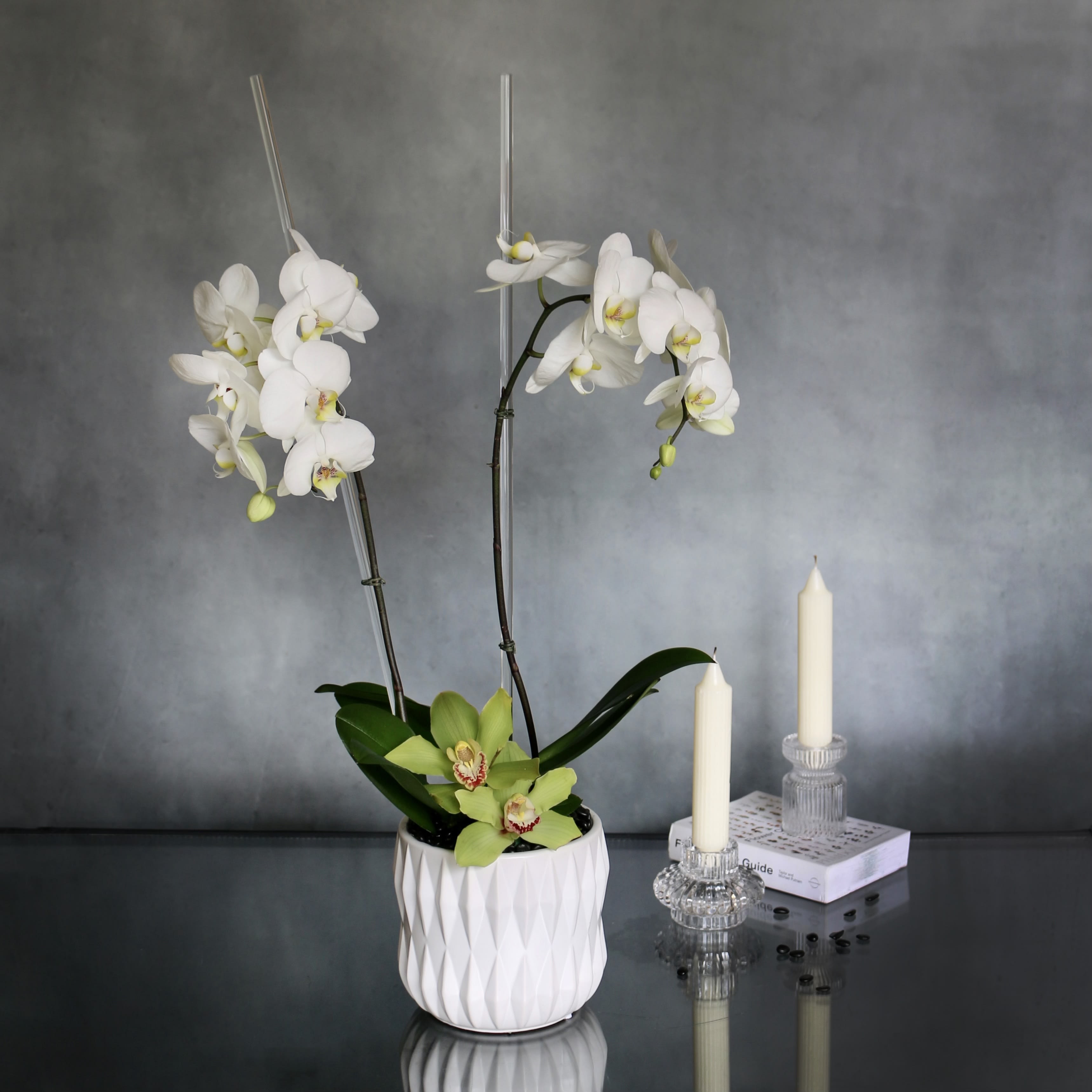Simplistic Orchid  - Our Orchid piece consists of two simple white Orchids accented with green Cymbidum orchids at the bottom. All arranged within a white ceramic vase.  