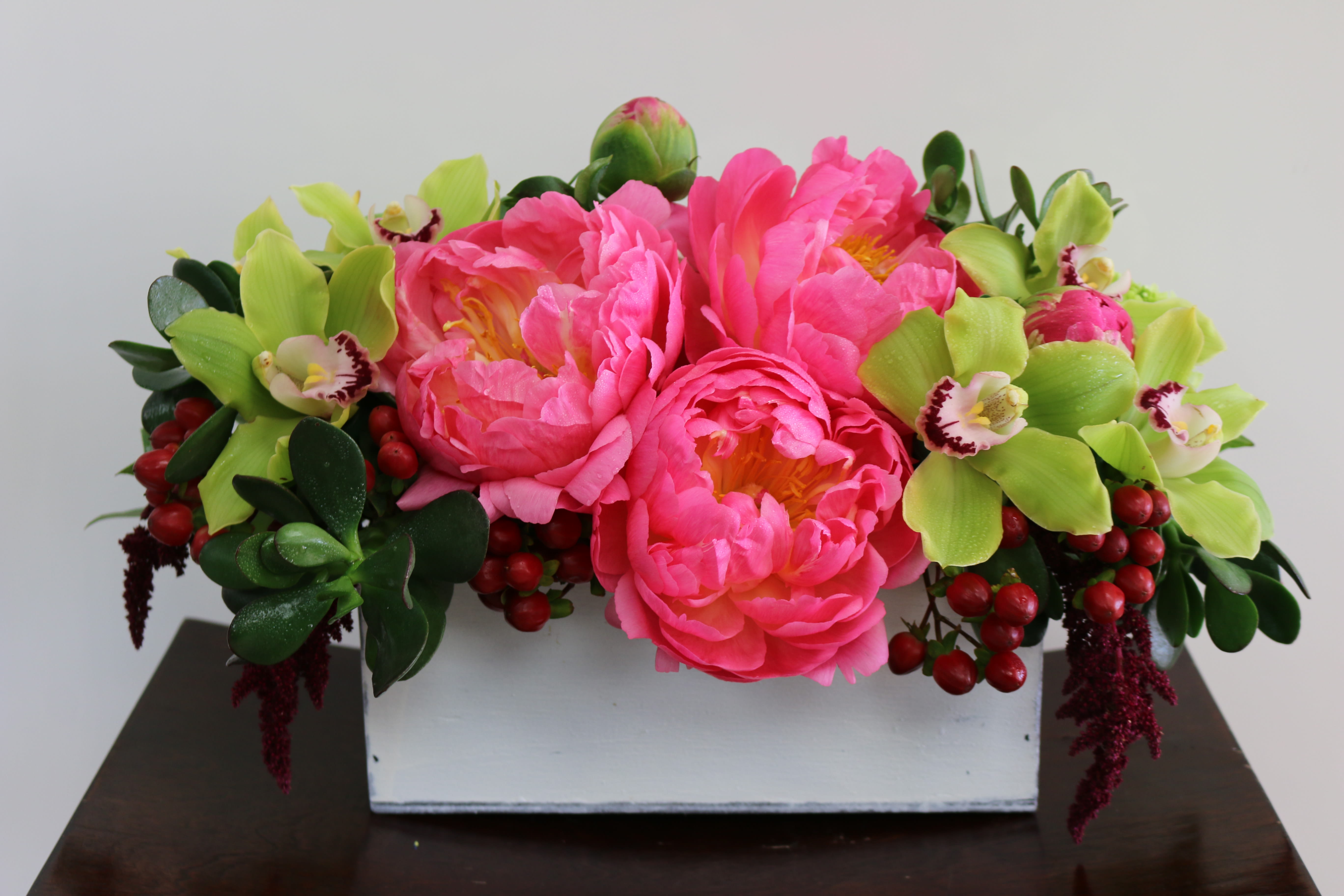 Peony Daydreams - Perfect for that special someone or special occasion.... this chic rectangular wooden box radiates beauty and color in this glorious mix of delicate Orchids, and large pink Peonies, with lovely greens and berries.  